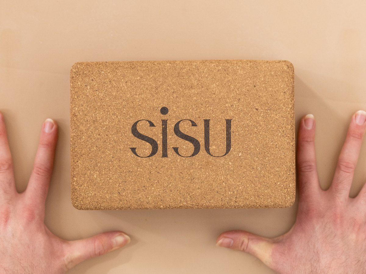 Hands resting either side of a SiSU cork block on a mat